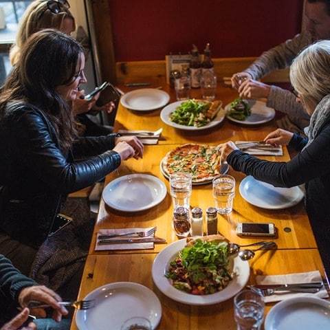 a group of people sitting at a table eating food