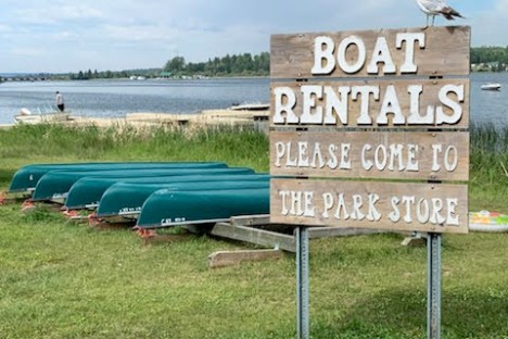 a sign on a wooden bench sitting in the grass