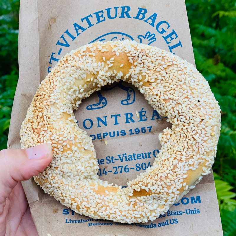 a hand holding a half eaten donut