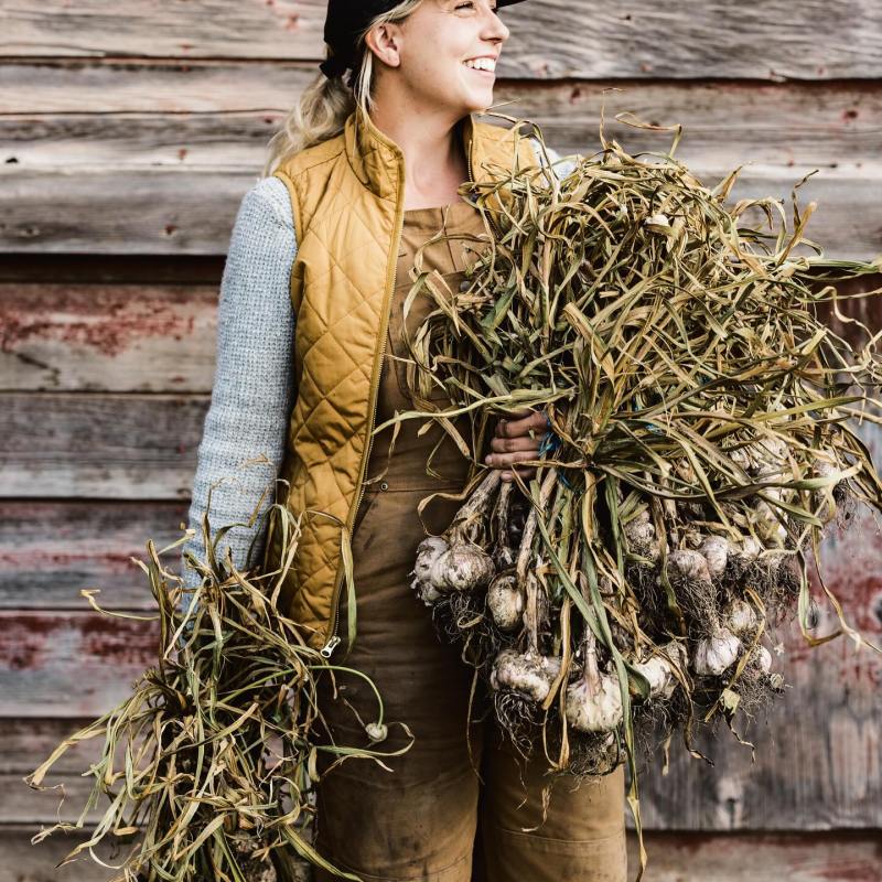 a woman standing in front of a wooden fence
