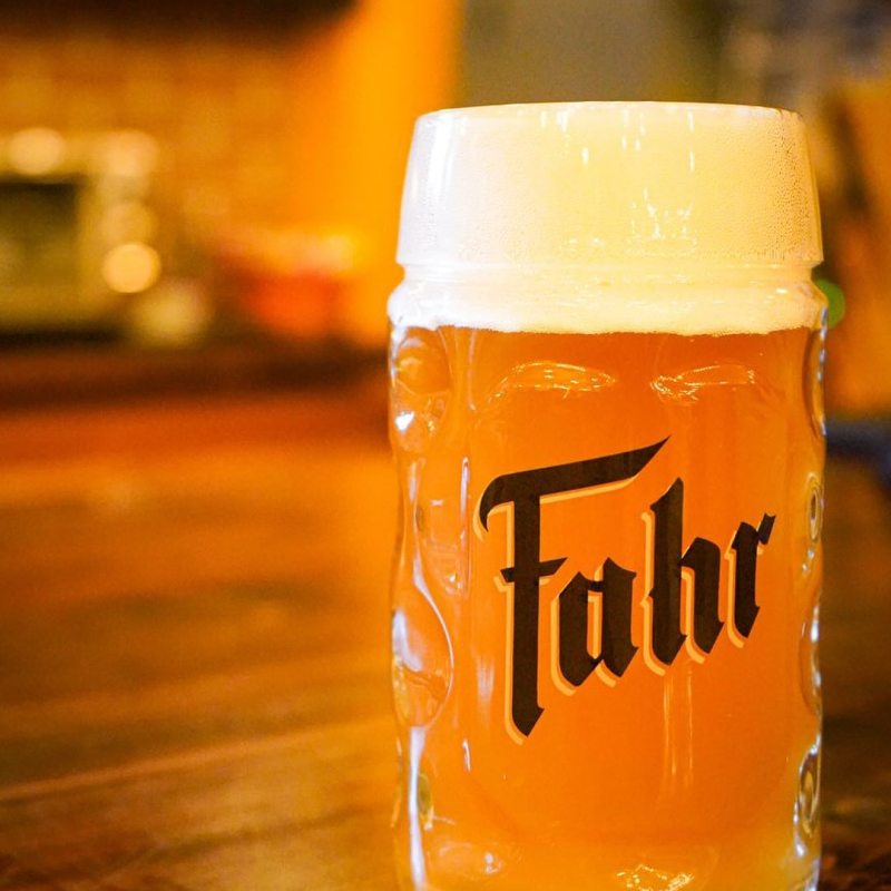 a close up of a bottle and a glass of orange juice