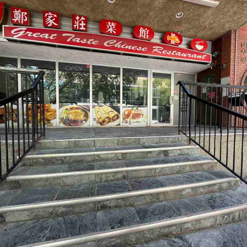 Entrance of a Chinese restaurant with a red sign and stairs leading up.